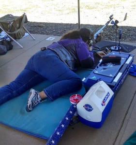 Nancy Tompkins shooting.  Smallbore shooters use personal windmills to help determine wind speed and direction.